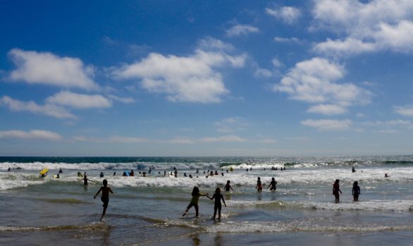 Children play in the waves of the Pacific Ocean at Santa Monica Beach