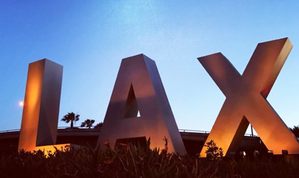 Dusk and the LAX sign welcome travelers to Los Angeles International Airport